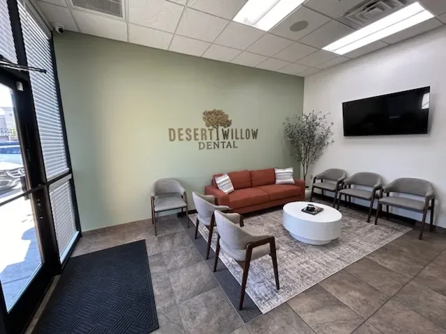 Patient waiting room with Desert Willow Dental wall lettering and lounge seating